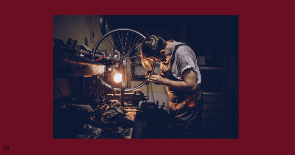 a guy fixing his wheel and working hard 
